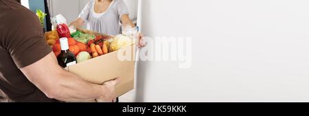 Online Grocery Delivery To Woman At Home Stock Photo