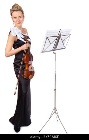 La musique est sa vie. Un violoniste magnifique debout devant un stand de partitions - isolé. Banque D'Images