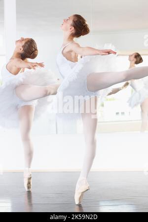 Répétition, répétition, répétition. Prise de vue en longueur de deux répétitions de ballerines dans un studio. Banque D'Images