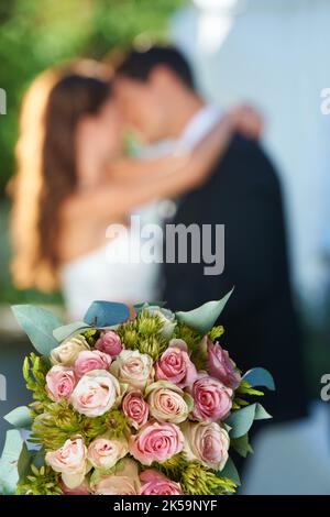 Beau bouqet. Heureux newlyweds avec foyer sur un bouquet en premier plan. Banque D'Images