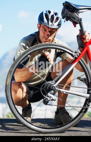 Sécuriser la sécurité de son vélo. Un cycliste vérifiant la roue de son vélo. Banque D'Images