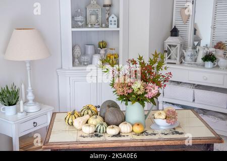 arrangement d'automne avec bouquet de fleurs d'hortensia, hanches roses, feuilles d'érable et citrouilles Banque D'Images