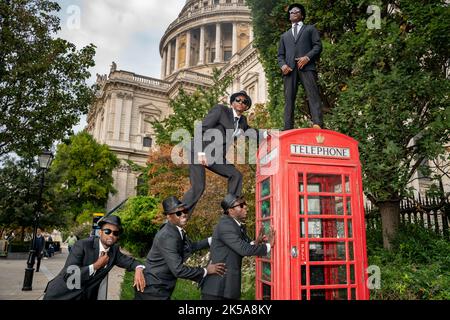 Bilal Musa Huka, Rashid Amini Kulembwa, Seif Mohamed Mlevi, Peter Mnyamosi Obunde et Mohamed Salim Mwakidudu AKA les frères Blues noirs montrent leurs compétences acrobatiques sur et dans une boîte téléphonique rouge de londres contre le fond de la cathédrale St Paul. Les Black Blues Brothers sont une troupe d'acrobates qui se sont produits pour le Pape François au Vatican, à la famille royale britannique et au Royal Variety Show. Les Black Blues Brothers font une tournée au Royaume-Uni avec leur spectacle qui est un hommage acrobatique au légendaire film culte. Les frères Black Blues ont utilisé une légendaire Red Phone Box de Londres pour un p Banque D'Images