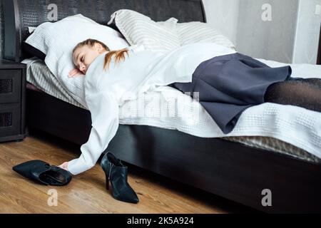 Épuisement professionnel, stress chronique en milieu de travail, épuisement. Femme d'affaires fatiguée surtravaillée stressée jeune femme allongé sur le lit après le travail Banque D'Images