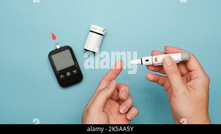 Vue au-dessus de l'homme prenant un échantillon de sang avec le stylo lancet. Test d'échantillon de sang, concept de diabète Banque D'Images