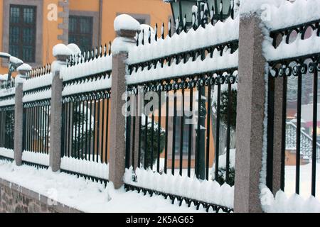clôture en fer enneigée d'un bâtiment en pierre Banque D'Images