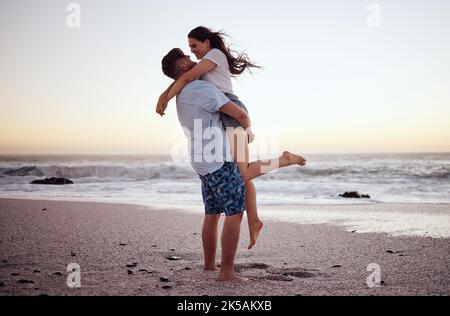 Couple heureux à la plage de remontée mécanique et de célébrer l'amour sur le coucher de soleil romantique tropical océan eau Hawaii vacances de luxe voyage ou vacances. Femme et homme Banque D'Images