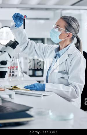 Scientifique, pathologie et science du sang ou de l'ADN femme travaillant dans un laboratoire pour la recherche covid, l'innovation et la guérison avec tube à essai d'échantillon. Analyses et Banque D'Images