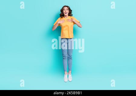 Pleine photo de jolie fille impressionnée vêtue jaune t-shirt saut haut bras pointant elle-même isolé teal couleur fond Banque D'Images