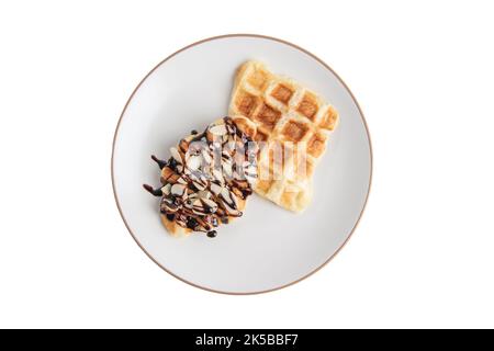 Croffes avec garniture de sauce au chocolat aux amandes et caramel sur l'assiette, vue du dessus Banque D'Images