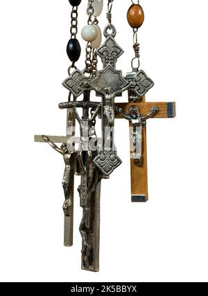 Gros plan d'un groupe de crucifix en métal et en bois et de perles rosaires isolées sur fond blanc, photographie. Banque D'Images