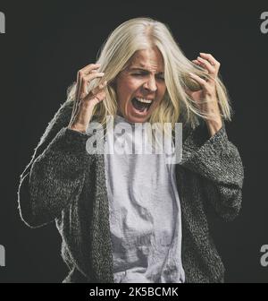 Cri frustré et furieux de femme âgée souffrant de problèmes de santé mentale à la retraite avec maquette. Rage de la femme âgée souffrant de colère, ptsd et Banque D'Images