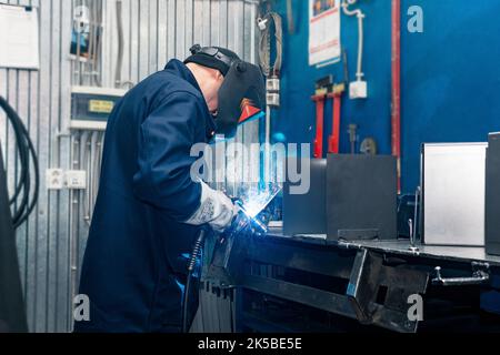 Perm, Russie - 21 septembre 2022 : soudeur au travail, soudeur de pièces métalliques en atelier Banque D'Images