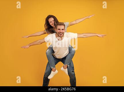 Écartez vos ailes et envolez-vous.Une femme heureuse aime faire du pigeyback sur un gars.Profitez de chaque instant Banque D'Images