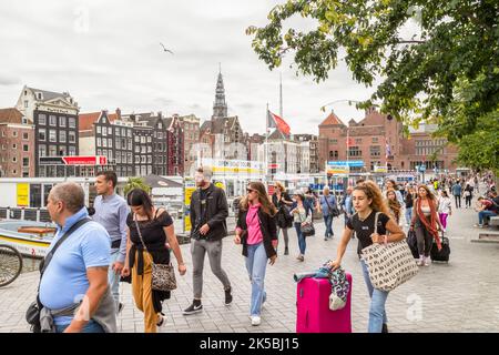 Les résidents et les touristes se promènent le long des croisières sur le canal sur le Damrak dans le centre d'Amsterdam. Banque D'Images