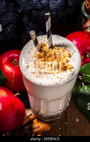 Milk-shake aux pommes chargé maison, smoothie aux protéines de pomme d'automne rouge avec crumble à la tarte et épices, boisson de petit-déjeuner de saison d'automne saine, sur W confortable Banque D'Images