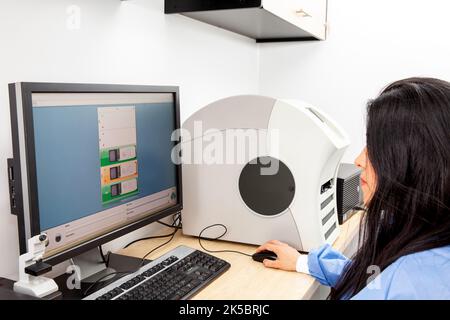 Jeunes femmes scientifiques qui numérisent des lames de microscope avec des échantillons de tissus pour des études de pathologie. Concept de diagnostic de cancer. Concept de technologie médicale. Banque D'Images