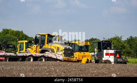 Vue sur les tracteurs garés dans le champ sous le ciel bleu à la campagne Banque D'Images