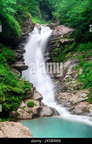 Cascade en cascade sur des rochers de montagne. Une cascade de montagne coule sur les rochers. Vue sur les chutes d'eau de la forêt tropicale. Banque D'Images