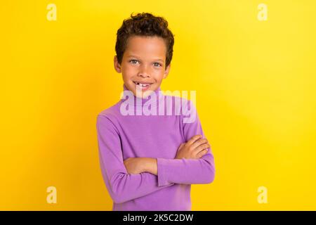 Photo portrait de mignon petit pupille garçon croix bras shopping promo habillé élégant violet vêtements isolés sur fond jaune couleur Banque D'Images