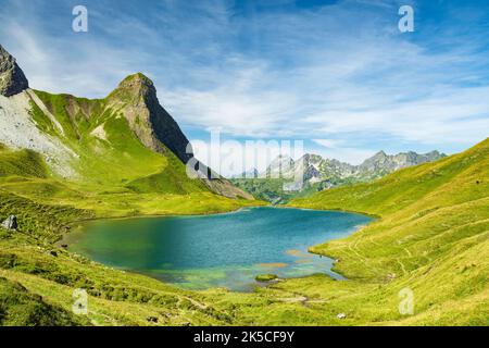 Lac idyllique entouré d'herbe et de montagnes en été. Rappensee, Alpes d'Allgäu, Bavière, Allemagne Banque D'Images
