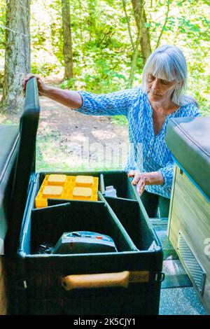 Femme stockant l'équipement de camping dans la boîte d'engrenages Radius Outfitters 500 Banque D'Images