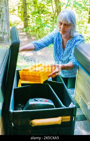 Femme stockant l'équipement de camping dans la boîte d'engrenages Radius Outfitters 500 Banque D'Images