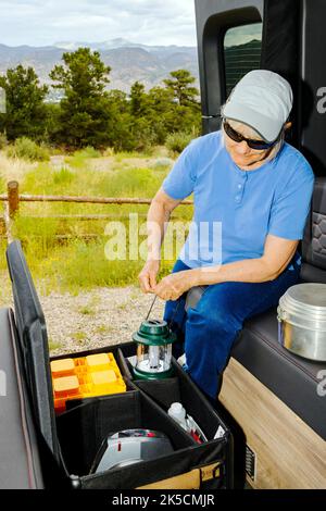 Femme stockant l'équipement de camping dans la boîte d'engrenages Radius Outfitters 500 Banque D'Images