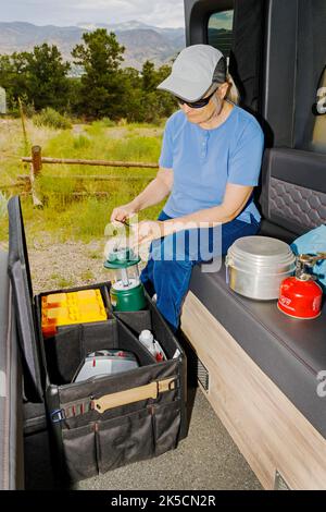 Femme stockant l'équipement de camping dans la boîte d'engrenages Radius Outfitters 500 Banque D'Images