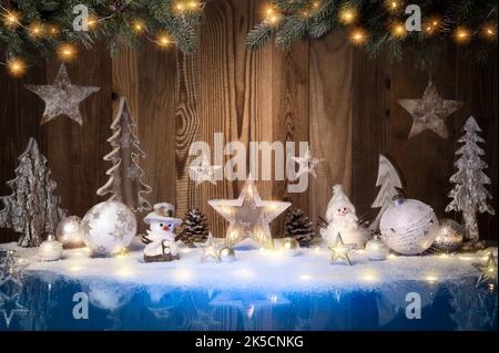 Décorations de Noël, lumières et neige sur une surface bleue et un fond en bois avec espace de copie Banque D'Images