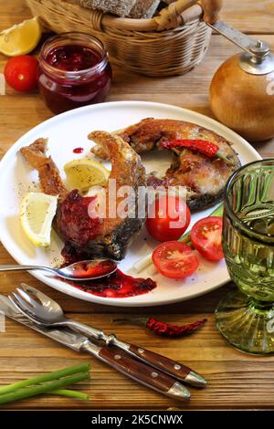 Carpe frite avec tkemali et vin blanc Banque D'Images