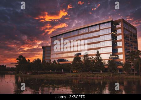 Photo d'un immeuble de bureaux commerciaux sous un ciel de coucher de soleil sur Lake Woodlands au Texas Banque D'Images