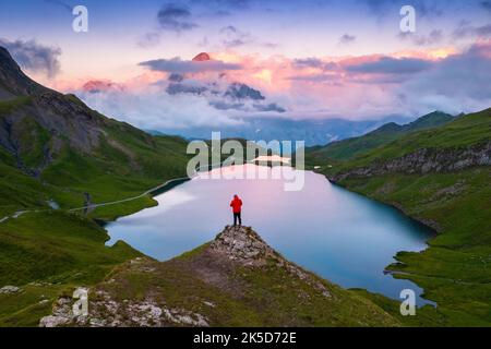 Vue aérienne d'une personne en admirant le lac Bachalpsee pendant un coucher de soleil d'été. Grindelwald, canton de Berne, Suisse, Europe. Banque D'Images