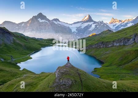 Vue aérienne d'une personne en admirant le lac Bachalpsee pendant un lever de soleil d'été. Grindelwald, canton de Berne, Suisse, Europe. Banque D'Images