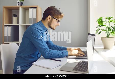 Programmeur professionnel millénaire plein de confiance travaillant dans un bureau moderne. Banque D'Images