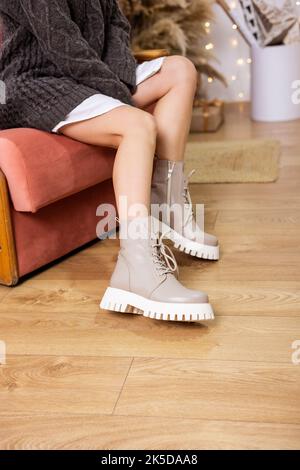 Une femme élégante se tient dans des chaussures beige. Gros plan sur les jambes des femmes avec des bottes vintage en cuir beige très tendance. Nouvelle collection saisonnière de chaussures pour Femme Banque D'Images