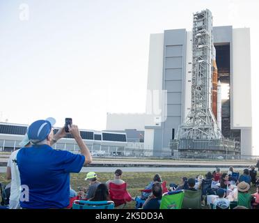 Des invités et des employés de la NASA regardent la fusée SLS (Space Launch System) de la NASA avec le vaisseau spatial Orion à bord, pour la première fois, à partir de High Bay 3 du bâtiment d'assemblage de véhicules, jeudi, 17 mars 2022, au Kennedy Space Center de la NASA en Floride. Avant l'essai en vol Artemis I de la NASA, la fusée SLS et l'engin spatial Orion entièrement empilés et intégrés feront l'objet d'une répétition en robe humide au Launch Complex 39B pour vérifier les systèmes et pratiquer les procédures de compte à rebours pour le premier lancement. Banque D'Images