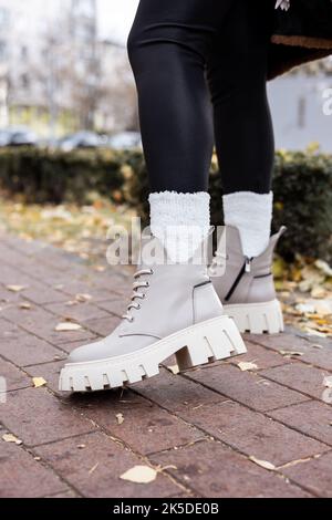 Une femme élégante se tient dans des chaussures beige. Gros plan sur les jambes des femmes avec des bottes vintage en cuir beige très tendance. Nouvelle collection saisonnière de chaussures pour Femme Banque D'Images
