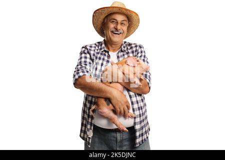 Fermier mature tenant un petit cochon et souriant isolé sur fond blanc Banque D'Images