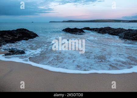 Vagues douces se brisant au crépuscule sur la plage de Harlyn Bay, sur la côte nord de Cornwall, en Angleterre, au Royaume-Uni Banque D'Images