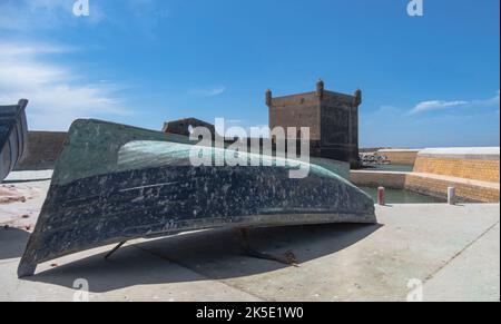 Vieux bateau de pêche bleu et vert au bord d'un port et une journée ensoleillée et lumineuse Banque D'Images