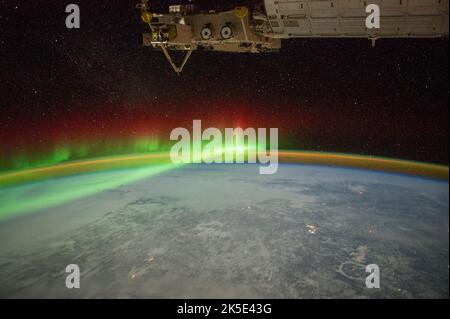 Photographié de la Station spatiale internationale le 3 février 2012. Les voiles et rideaux verts de l'aurora borealis s'étendant au-dessus de Québec, Canada. En bas à droite, un cercle de glace sur le réservoir gelé qui occupe maintenant le cratère d'impact de Manicouagan (70km à travers). Les lumières de la ville révèlent de petites colonies. L'aurore borealis (aurores boréales) est la lumière qui brille lorsque les particules chargées de la magnétosphère sont accélérées par les tempêtes du soleil. L'arc de lumière le plus évanescent qui parallèle à l'horizon est connu sous le nom de lueur aérienne. Une version optimisée d'une image d'origine de la NASA. Crédit: NASA Banque D'Images