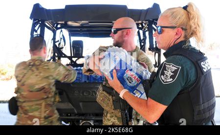 La Garde nationale de l'armée de Floride SPC. Caleb Cartwright affecté à la troupe Charlie, 1st Escadron, 153rd Calvaire Regiment décharge de l’eau d’un véhicule de sous-ministre du shérif du comté de Lee lors des interventions d’urgence de l’ouragan Ian, à Sanibel Island Florida, 3 octobre 2022. Des approvisionnements comme la nourriture et l’eau ont été coupés de l’île en raison de la destruction de l’ouragan Ian qui a limité les résidents à entrer ou à sortir par terre. (Photo de la Garde nationale de l'armée de Floride par le sergent d'état-major. Cassandra Vieira) Banque D'Images