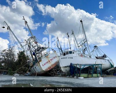 Les photos montrent des bateaux à crevettes endommagés et des débris à la suite de l'ouragan Ian à fort Myers. L'ouragan Ian a quitté cette marina de fort Myers détruite, avec des bateaux qui volait autour et des jetées en pulvérisation près d'un pont vers la plage de fort Myers. Banque D'Images