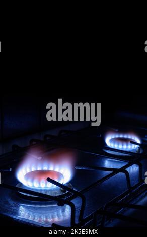 Le gaz propane brûle sur fond sombre avec un espace de copie noir, une vue verticale du poêle à gaz et une flamme bleue des brûleurs. Concept de coût du gaz, Gazprom, e Banque D'Images