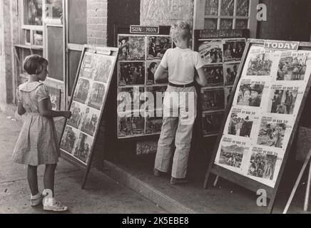 Enfants regardant des affiches devant le film, samedi, Steele, Missouri, 1938-08. Banque D'Images