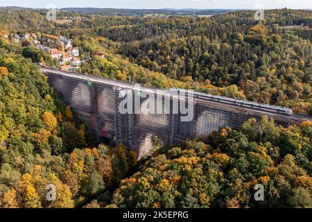 Saxe, Allemagne. 07th octobre 2022. 07 octobre 2022, Saxe, Jocketa: Un train de la Mitteldeutsche Regiobahn passe le pont d'Elstertal. La rénovation du pont ferroviaire vieux de plus de 150 ans dans la région de Vogtland se déroule selon le plan. Une bonne 36 000 des quelque douze millions de briques du deuxième plus grand pont de briques du monde doivent être remplacées. Les briques ont été faites sur mesure selon un modèle historique. De plus, les chemins de roulement sont en cours de reconstruction, a expliqué le chemin de fer. Selon le rail, la fin des rénovations est prévue pour la fin de 2025 Banque D'Images