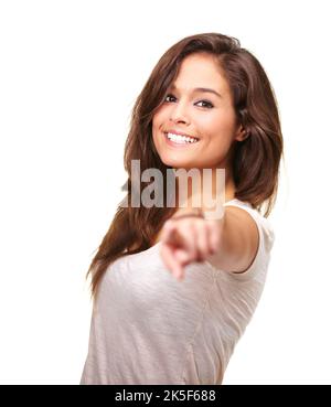 Elle sait ce qu'elle veut. Portrait en studio d'une jeune femme magnifique souriant et pointant vers l'appareil photo. Banque D'Images