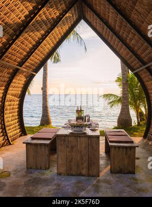 Dîner romantique sur la plage avec cuisine thaïlandaise au coucher du soleil sur l'île de Koh Mak Thaïlande. Banque D'Images