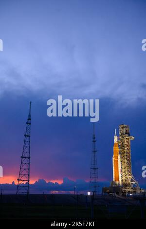 La fusée SLS (Space Launch System) de la NASA, à bord de l'engin spatial Orion, est vue au sommet du lanceur mobile du Launch 39B au Kennedy Space Center de la NASA, en Floride. La mission Artemis I est le premier test intégré des systèmes d’exploration spatiale profonde de l’agence : la fusée Space Launch System, l’engin spatial Orion et les systèmes de soutien au sol. La mission est la première d'une série de missions de plus en plus complexes sur la Lune. Le lancement de l'essai en vol sans équipage est prévu au plus tôt le 3 septembre à 2 h 17 HE. Avec les missions Artemis, la NASA atterrira la première femme et la première personne de couleur sur le Banque D'Images